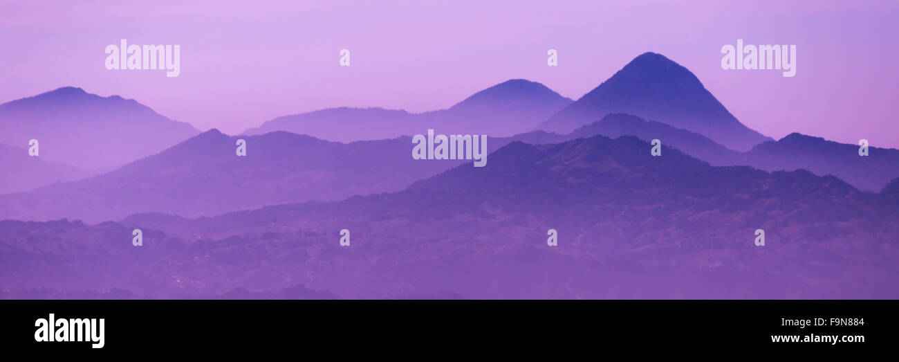 Skyscape of cold purple mountains with mist and fog close to Quetzaltenango Stock Photo