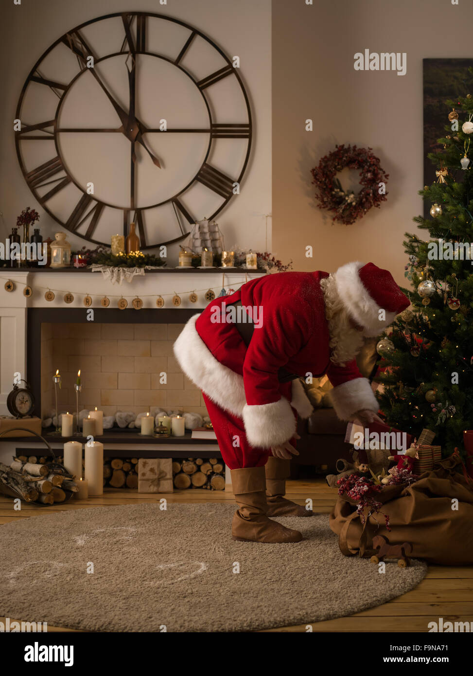Santa Claus Putting Gifts under Christmas Tree at Home Stock Photo - Alamy