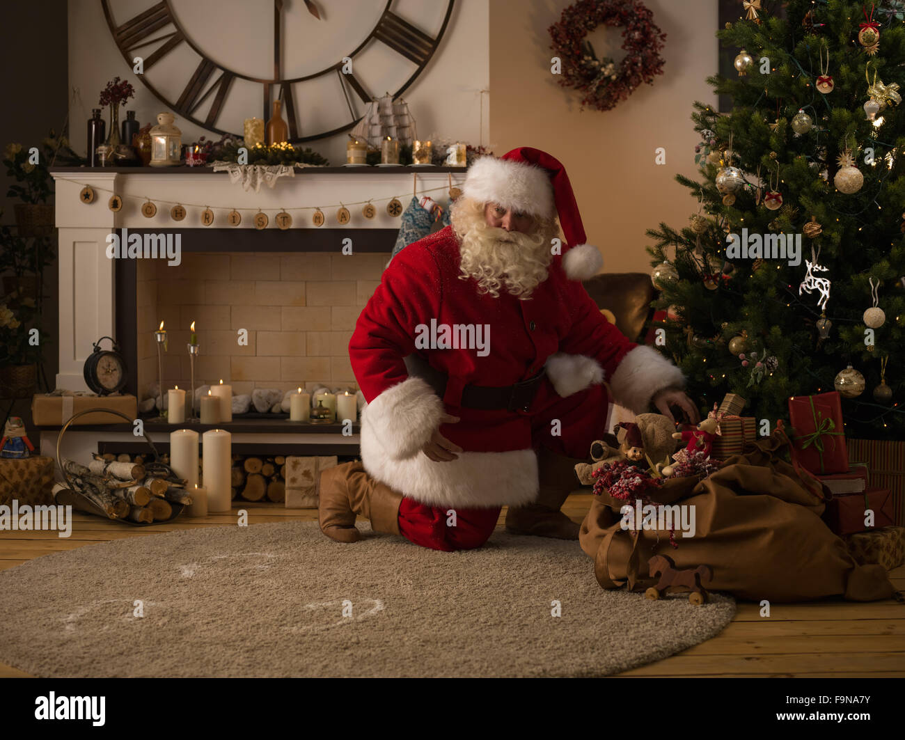 Santa Claus Putting Gifts under Christmas Tree at Home Stock Photo - Alamy
