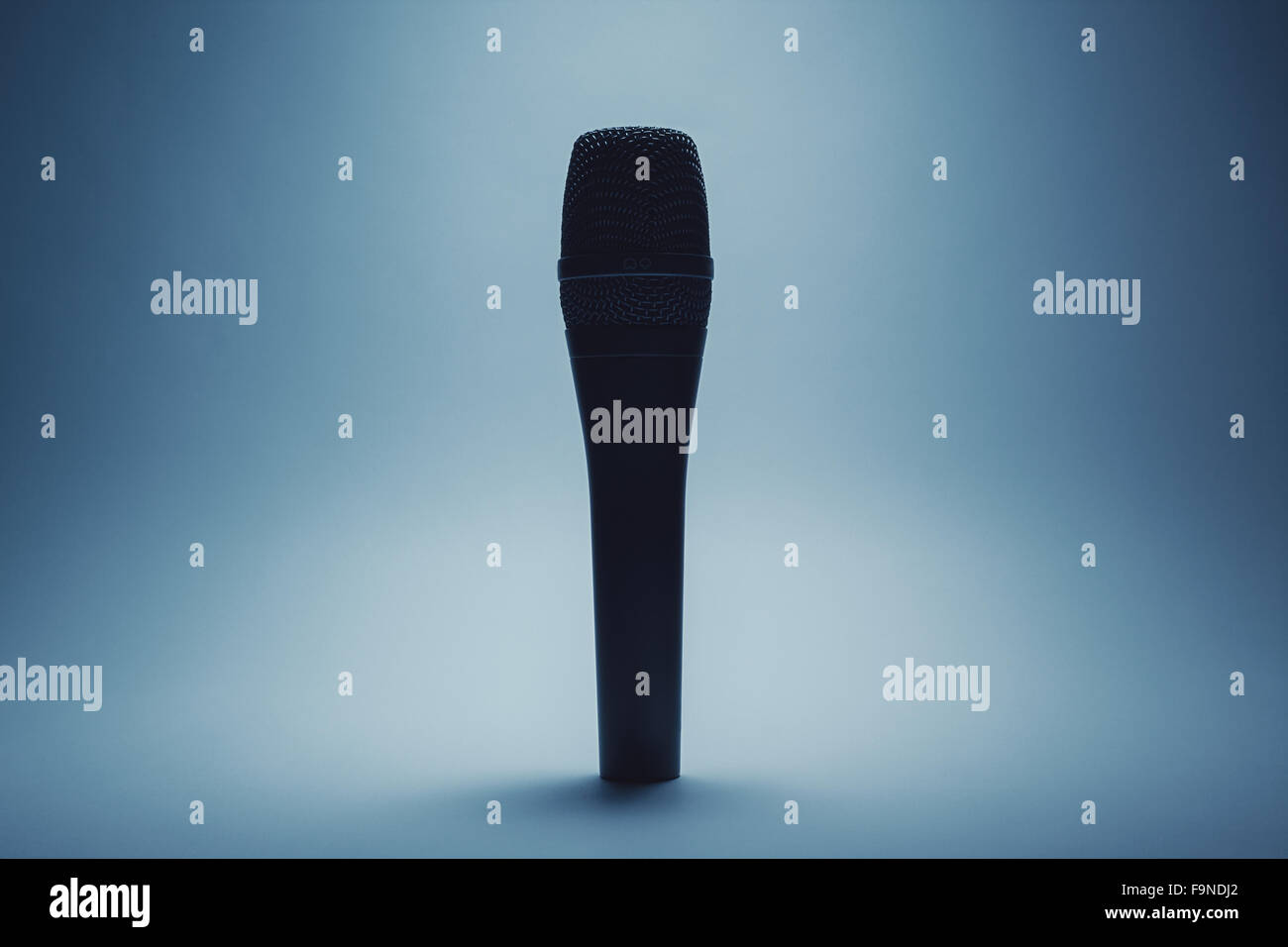 Closeup view of a modern microphone, highlighted parts by illumination. Stock Photo