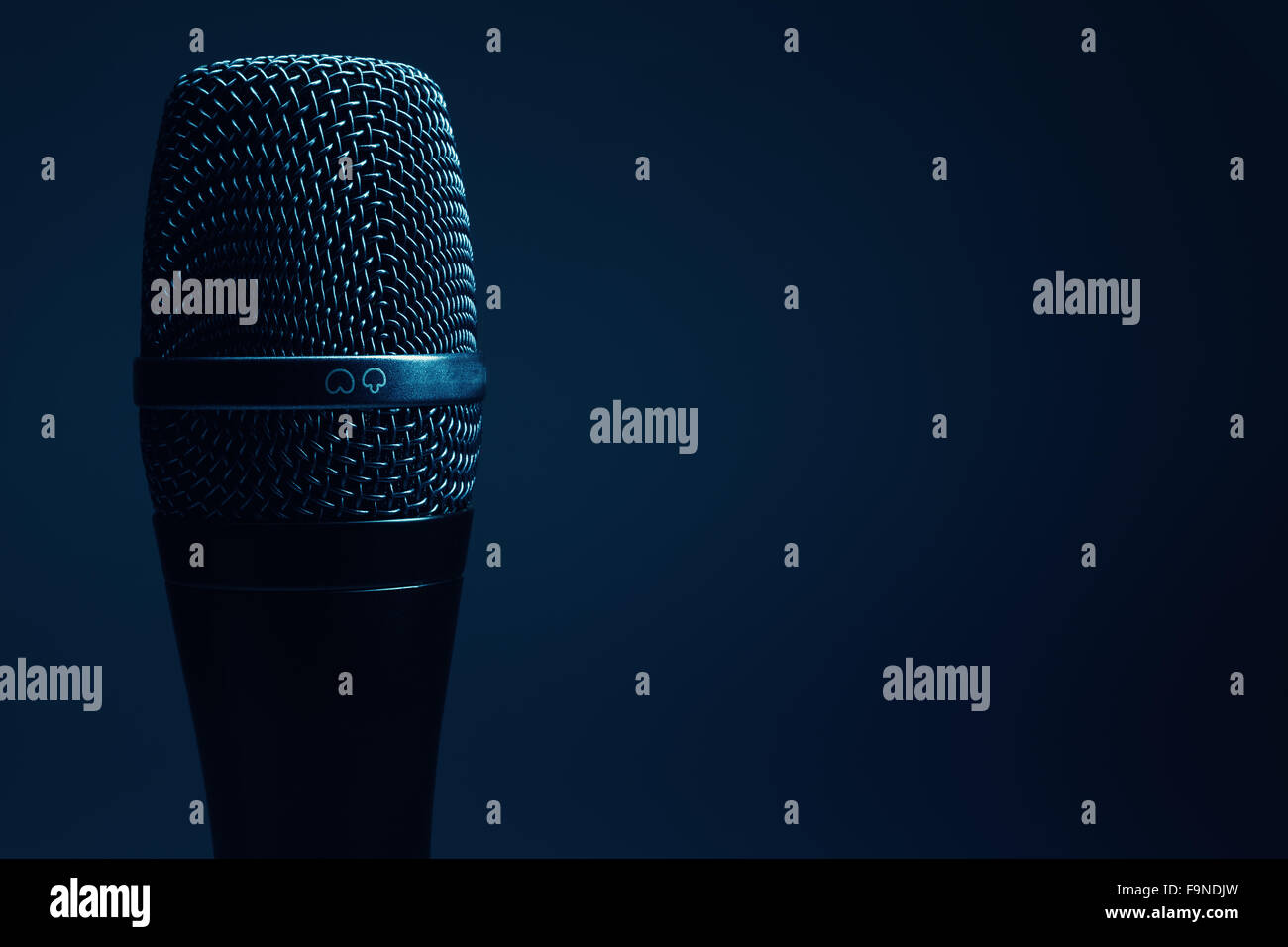 Closeup view of a modern microphone, highlighted parts by illumination. Stock Photo