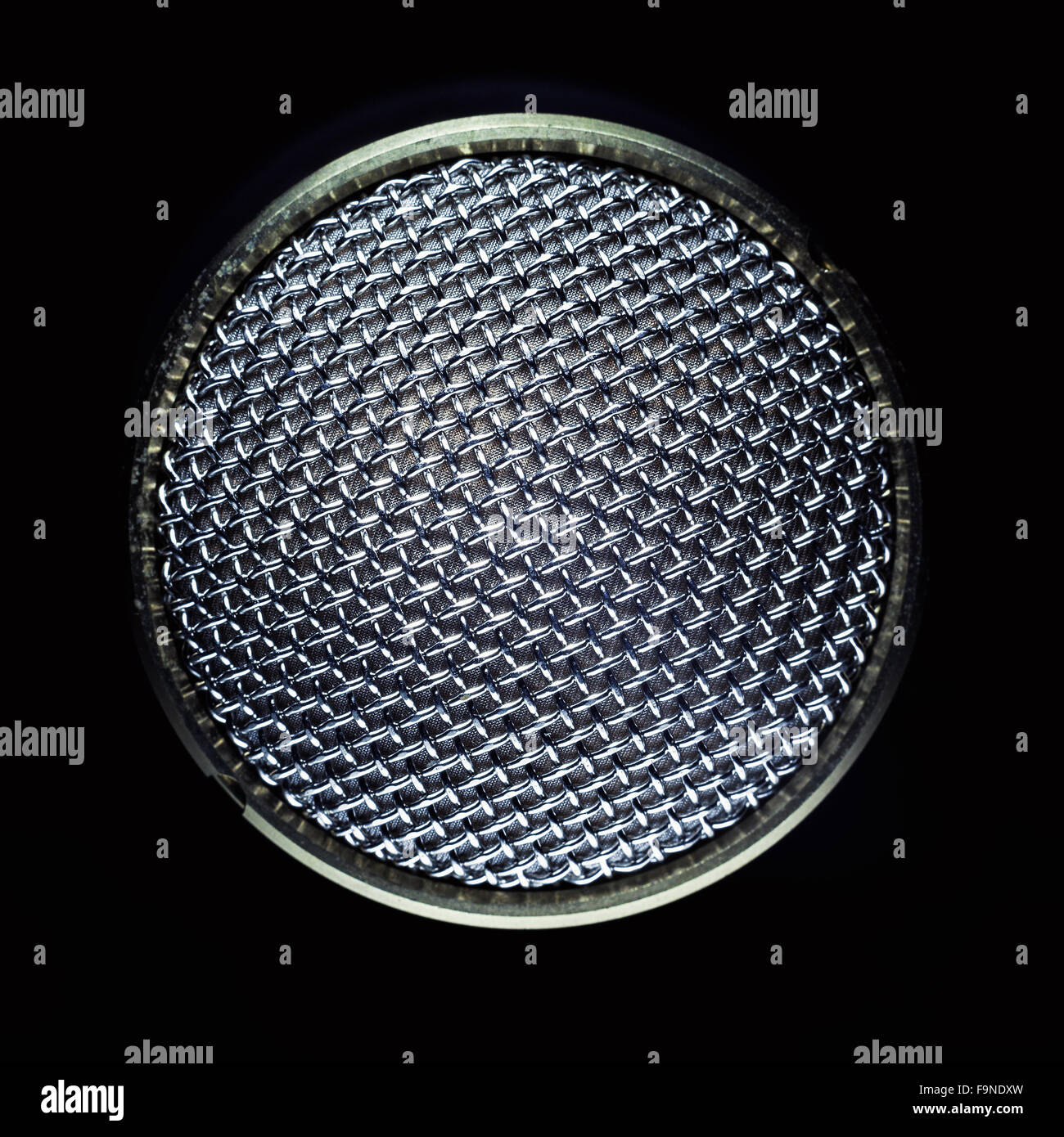 Closeup view of a modern microphone, highlighted parts by illumination. Stock Photo