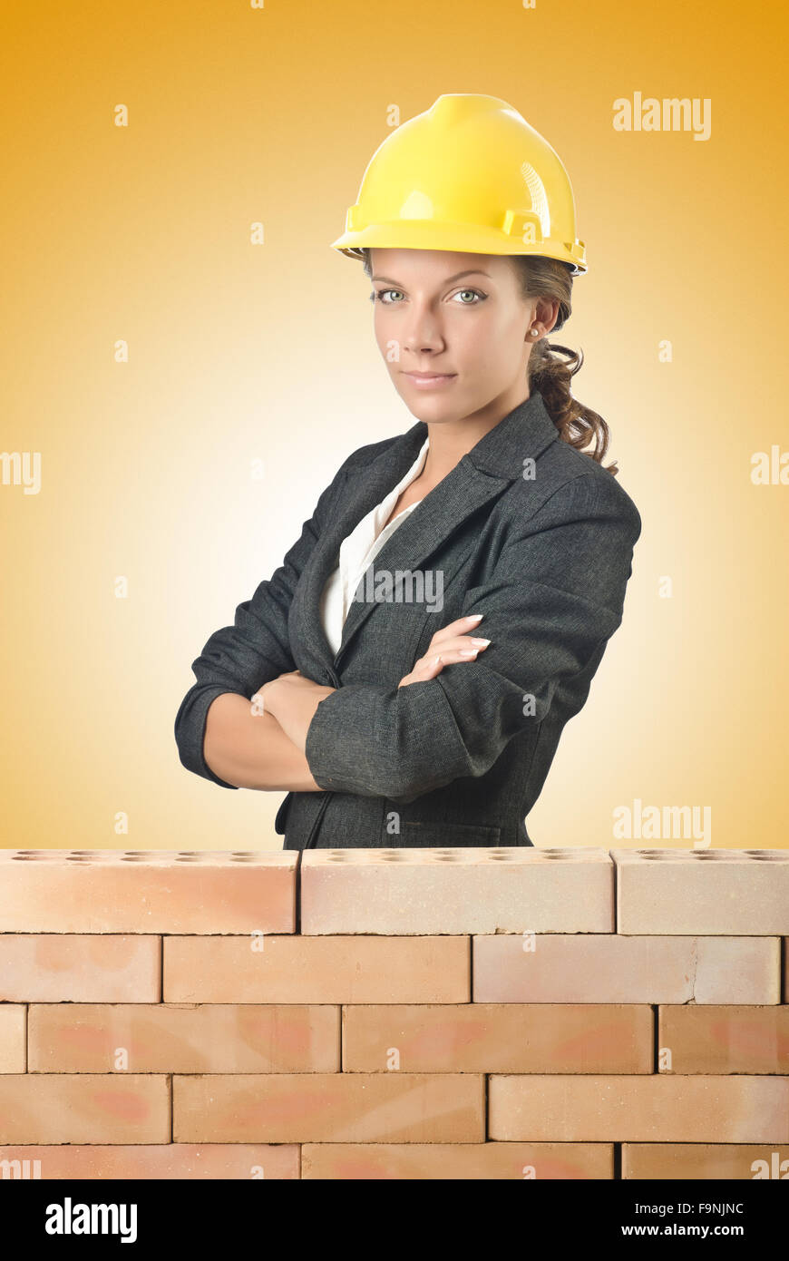 Young female builder near brick wall Stock Photo Alamy