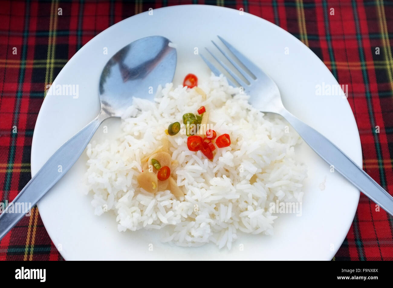 Boiled rice and chili on white dish with spoon and fork Stock Photo