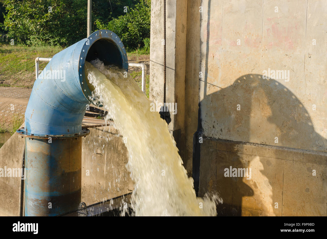 Large pump dumps water into an irrigation canal in the Central Valley. in Thailand. Stock Photo