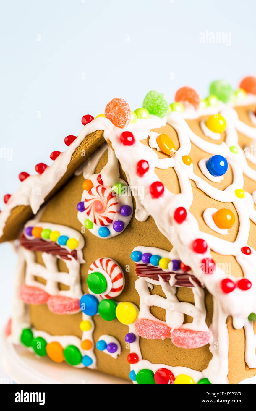 Gingerbread house decorated with white royal icing and bright candies ...