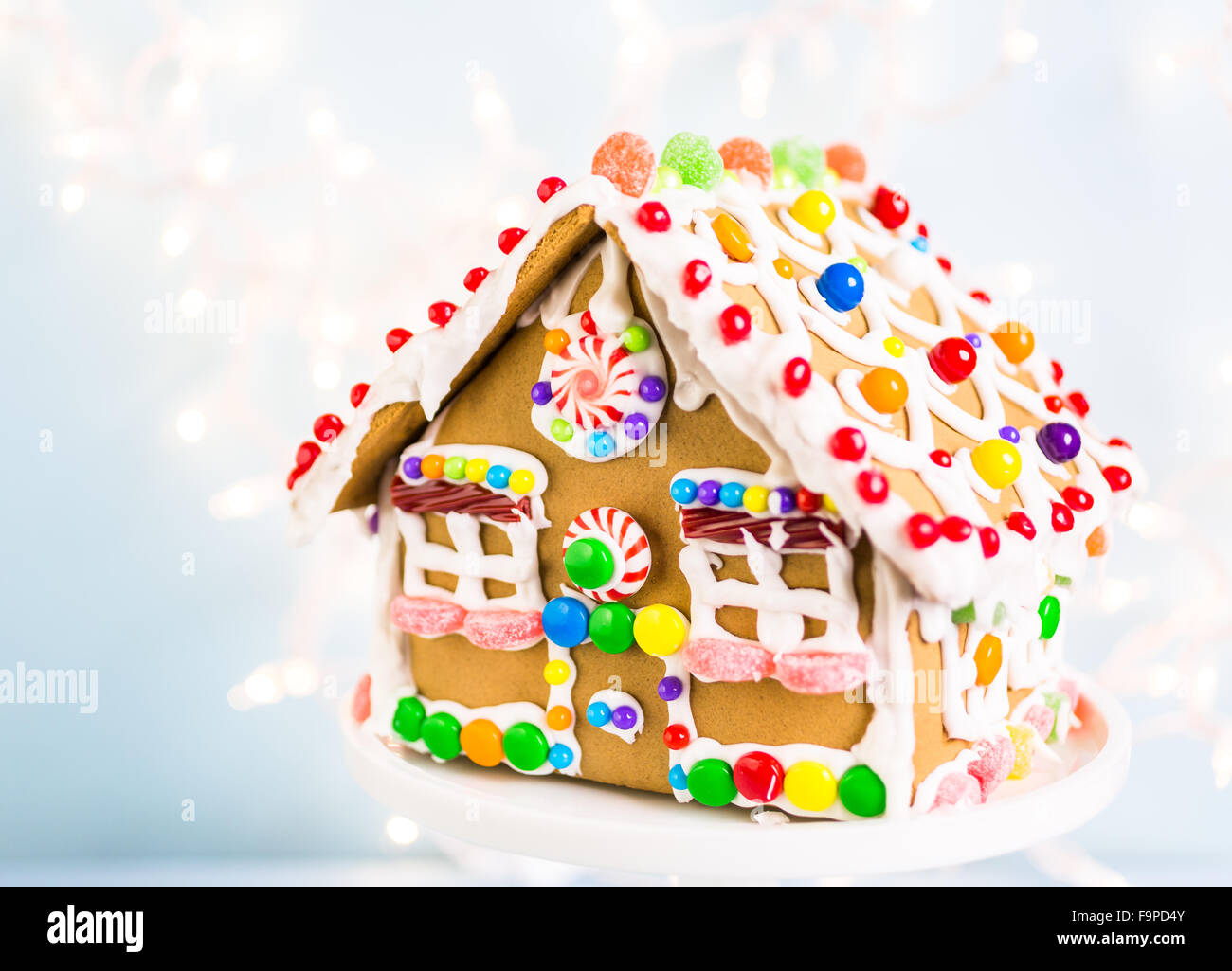 Gingerbread house decorated with white royal icing and bright candies ...