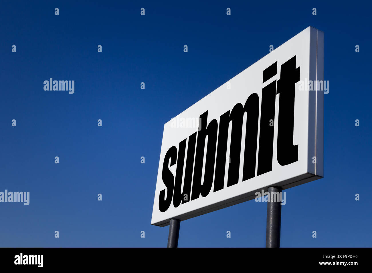 Big ad panel, embossed with the message 'Submit', isolated on blue sky. Stock Photo