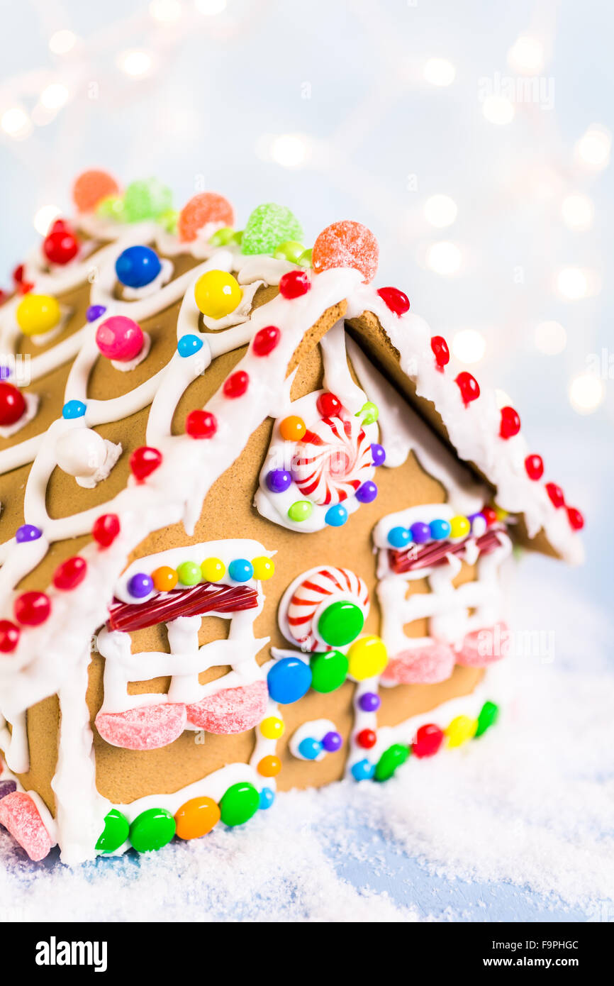 Gingerbread house decorated with white royal icing and bright candies ...