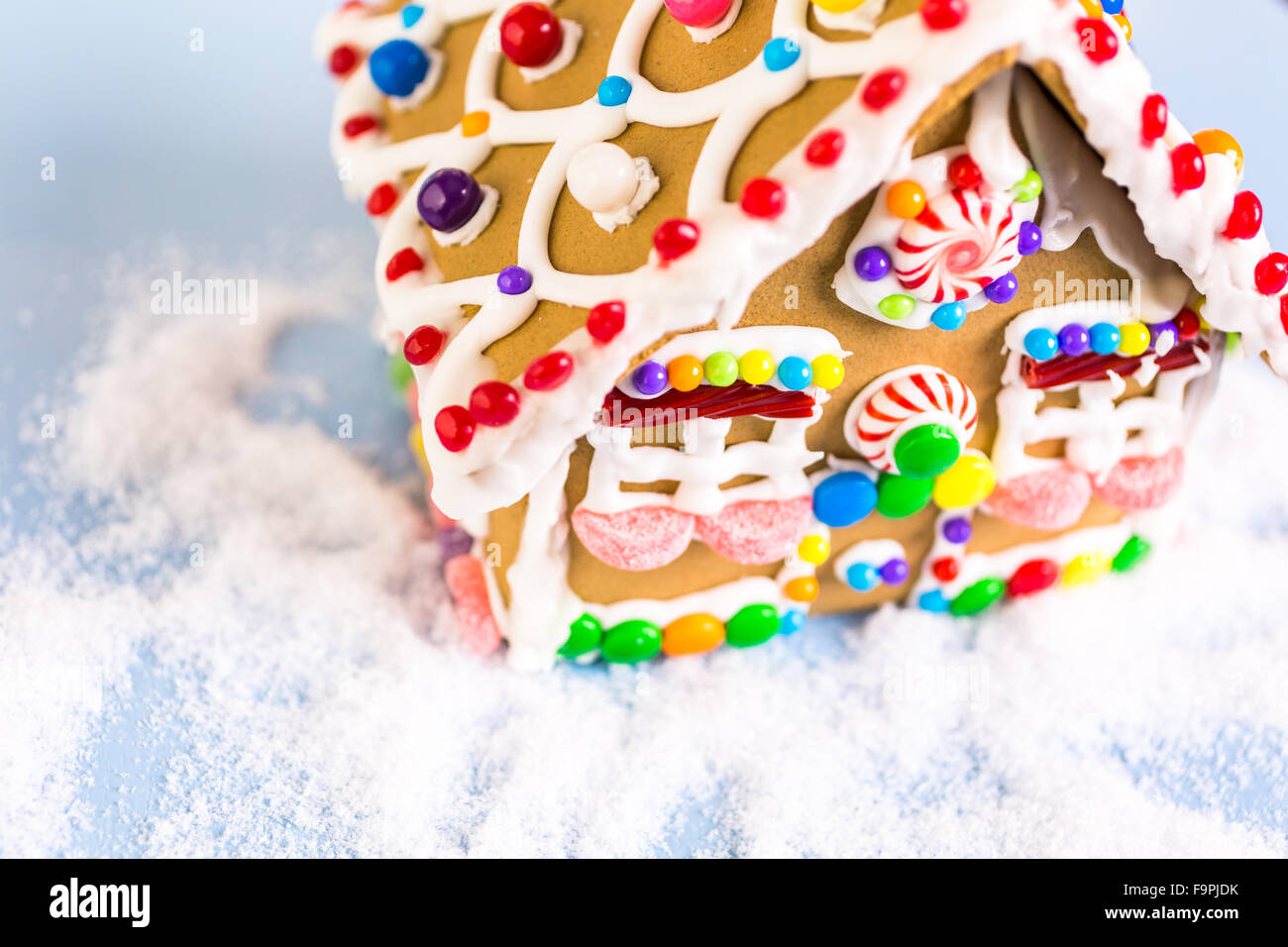 Gingerbread house decorated with white royal icing and bright candies ...