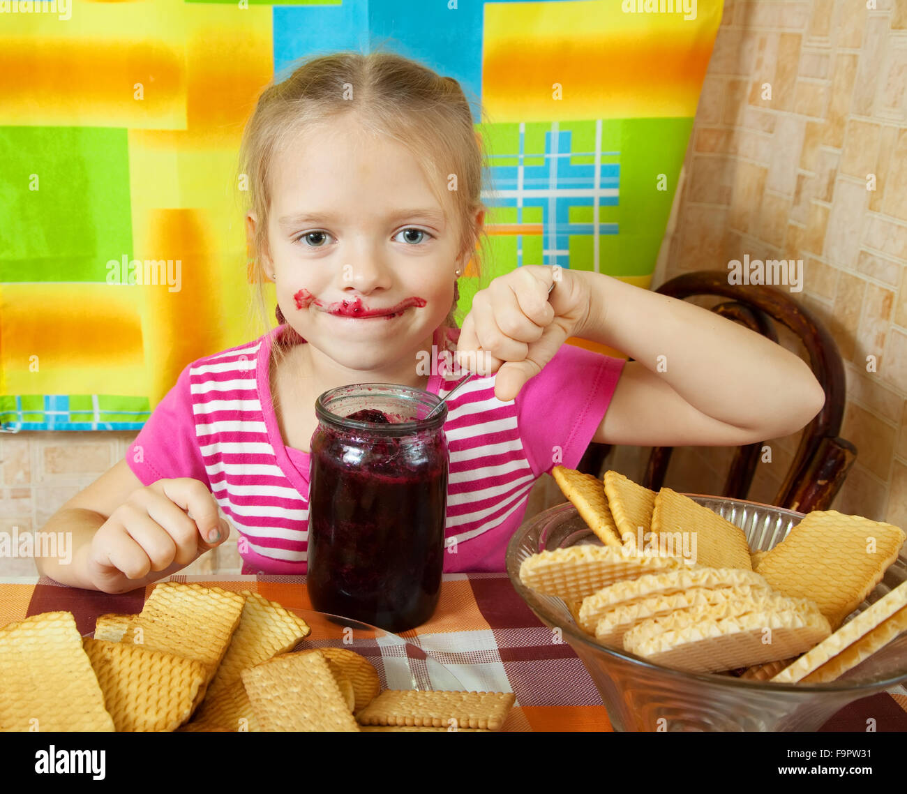 Little girl eating jam from jar at kitchen Stock Photo Alamy