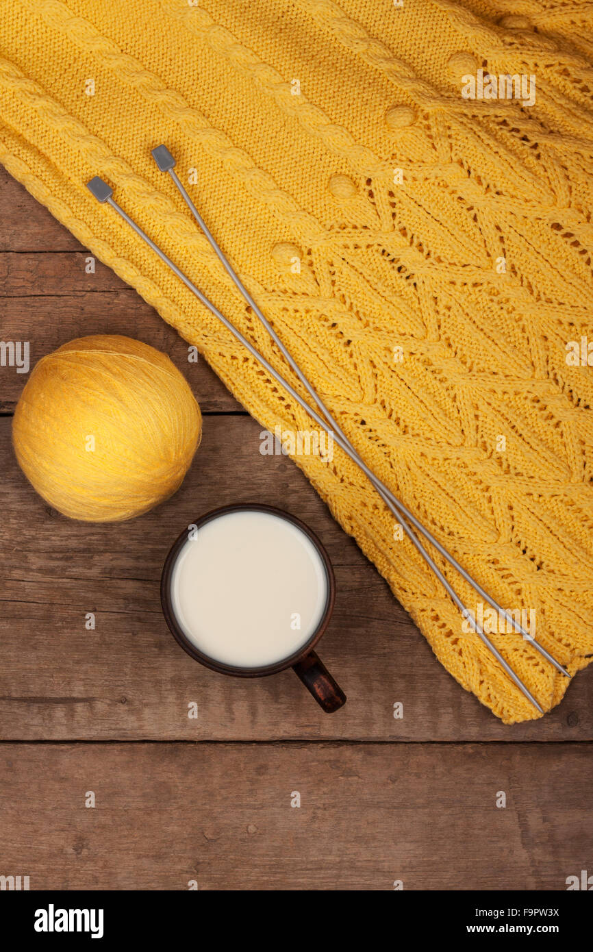 yellow thread for knitting with spokes and a knitted sweater Stock Photo