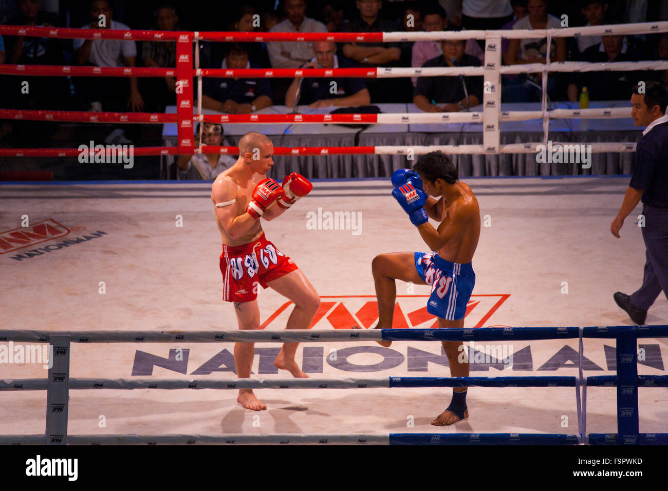 Male muay Thai kickboxers square off in knee, gloves raised defensive stance in a traditional way of feeling out the competition Stock Photo