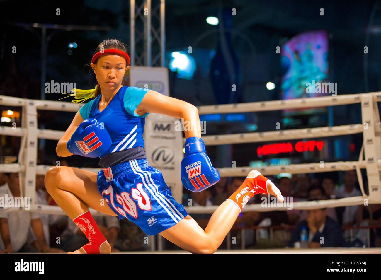 Female muay thai kickboxer performing a knee down kicking routine during a pre- kickboxing dance called the wai khru Stock Photo