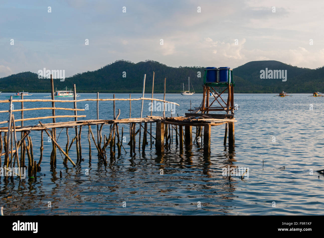 Small wood jetty in front of ocean and island Stock Photo