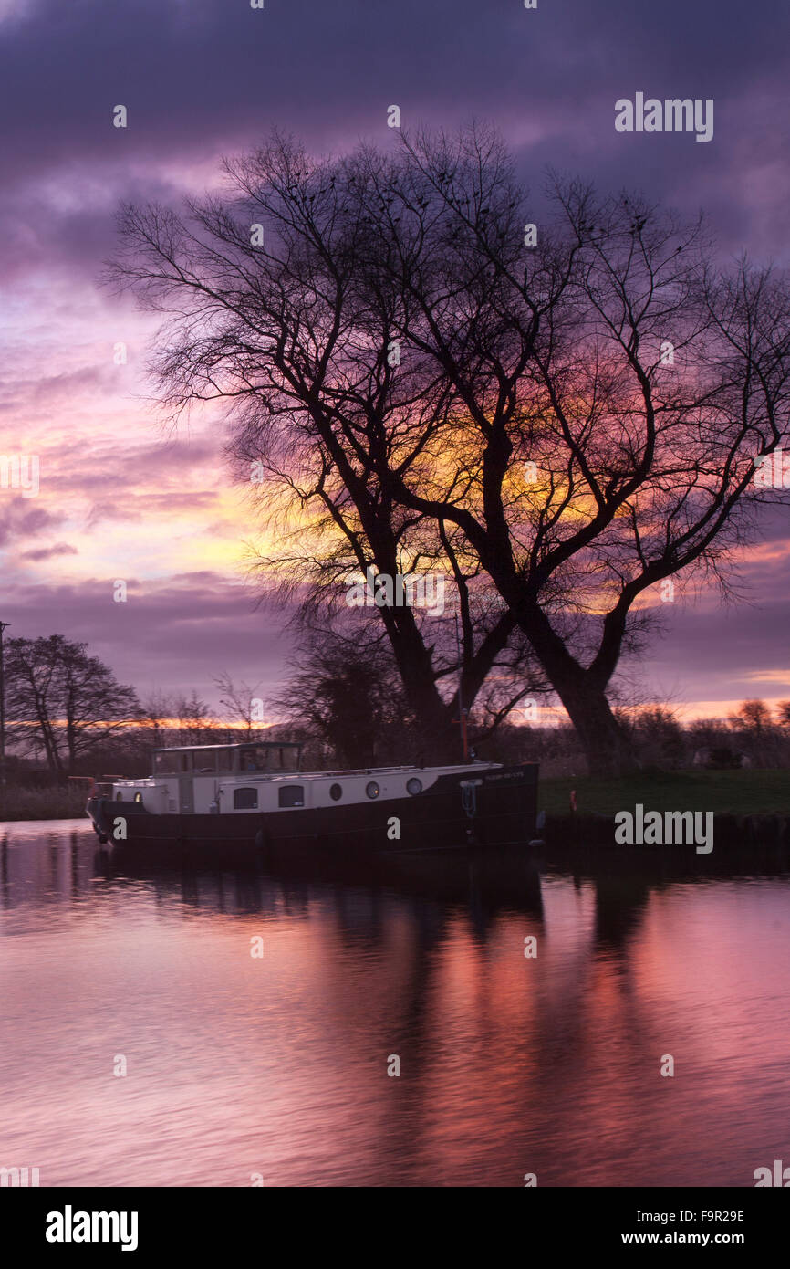 Rufford, Burscough, near Preston, Lancashire, UK 18th December, 2015.  UK Weather.  Continuing mild weather bringing a colourful start to the day with houseboats residents at St Mary's Marina, on the Leeds Liverpool canal, waking to purple skies and a glorious sunrise. Credit:  Mar Photographics/Alamy Live News Stock Photo