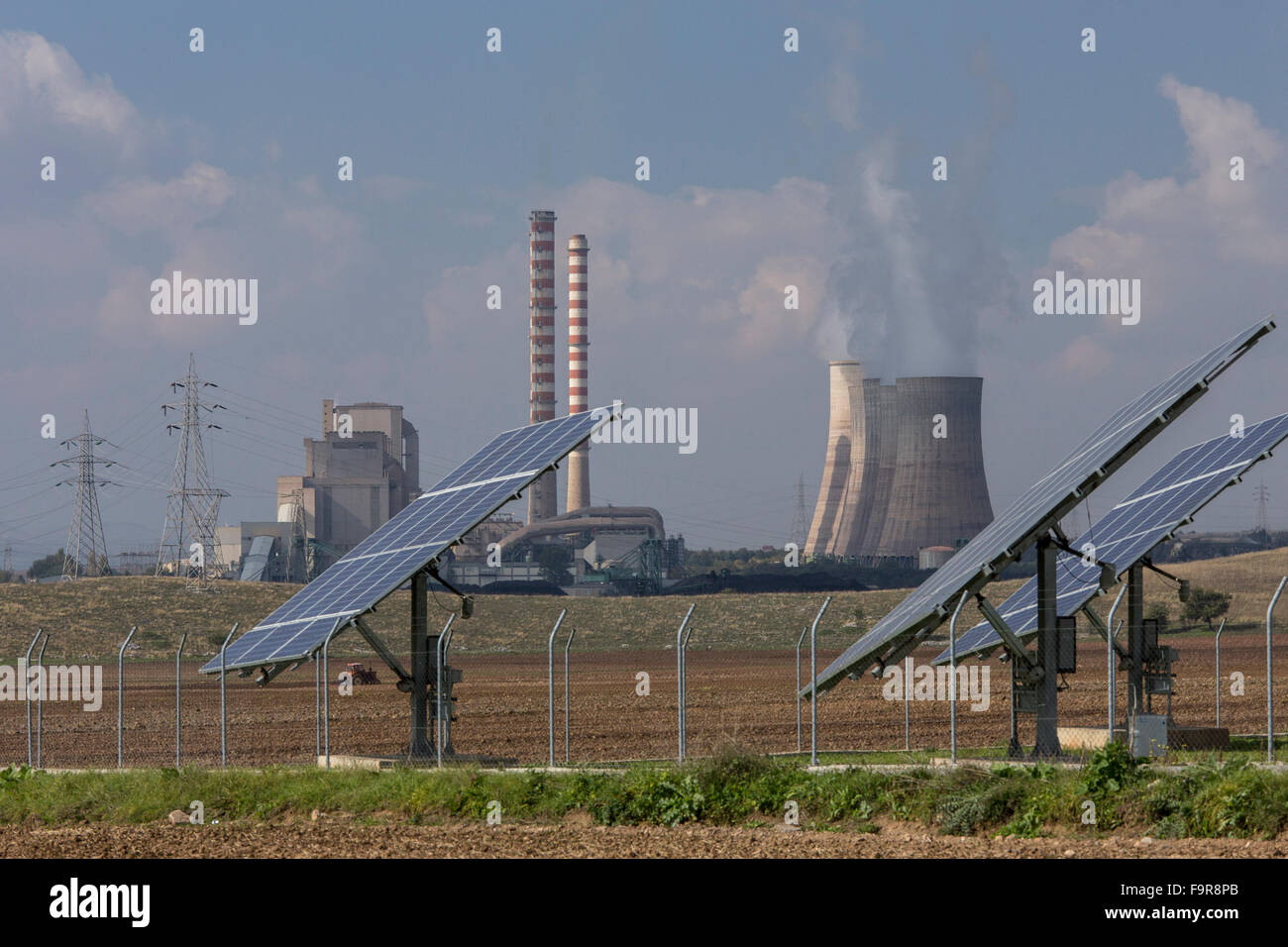 Solar panels and polluting coal-fired (lignite) power station beyond, Aghios Dimitrios, nr. Kozani, North Greece. Largest power Stock Photo