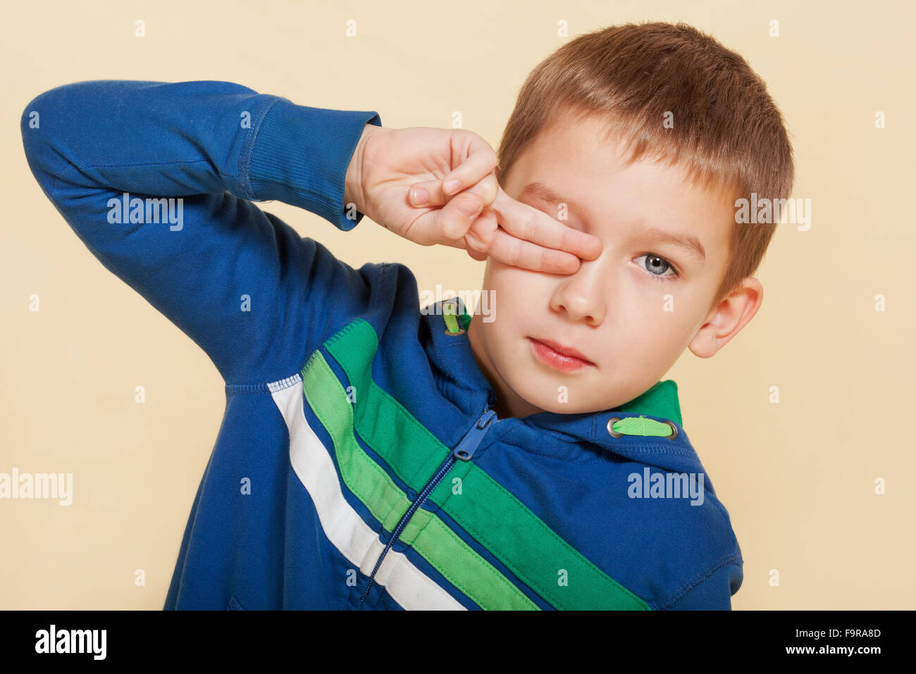 Young boy covering his eye Stock Photo - Alamy