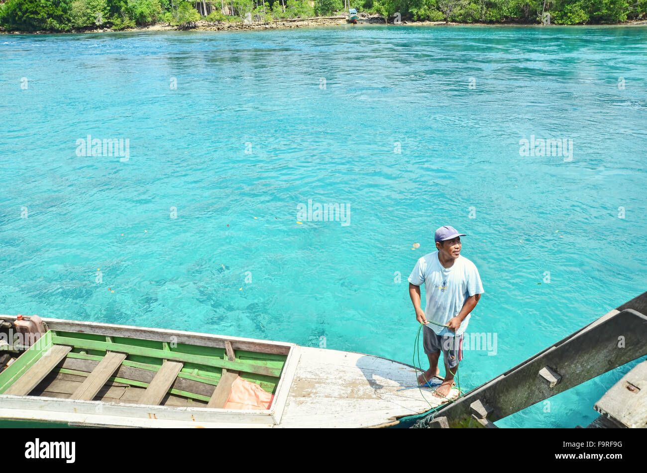 Man standing on his boat by the river in Labuan Cermin Stock Photo
