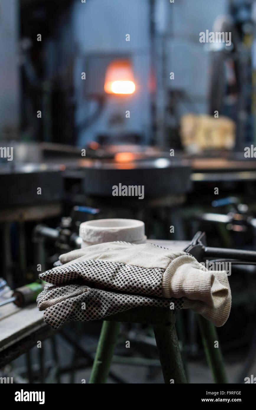 Protective gloves on a workbench at a glass blowing manufacture / glass furnace Stock Photo