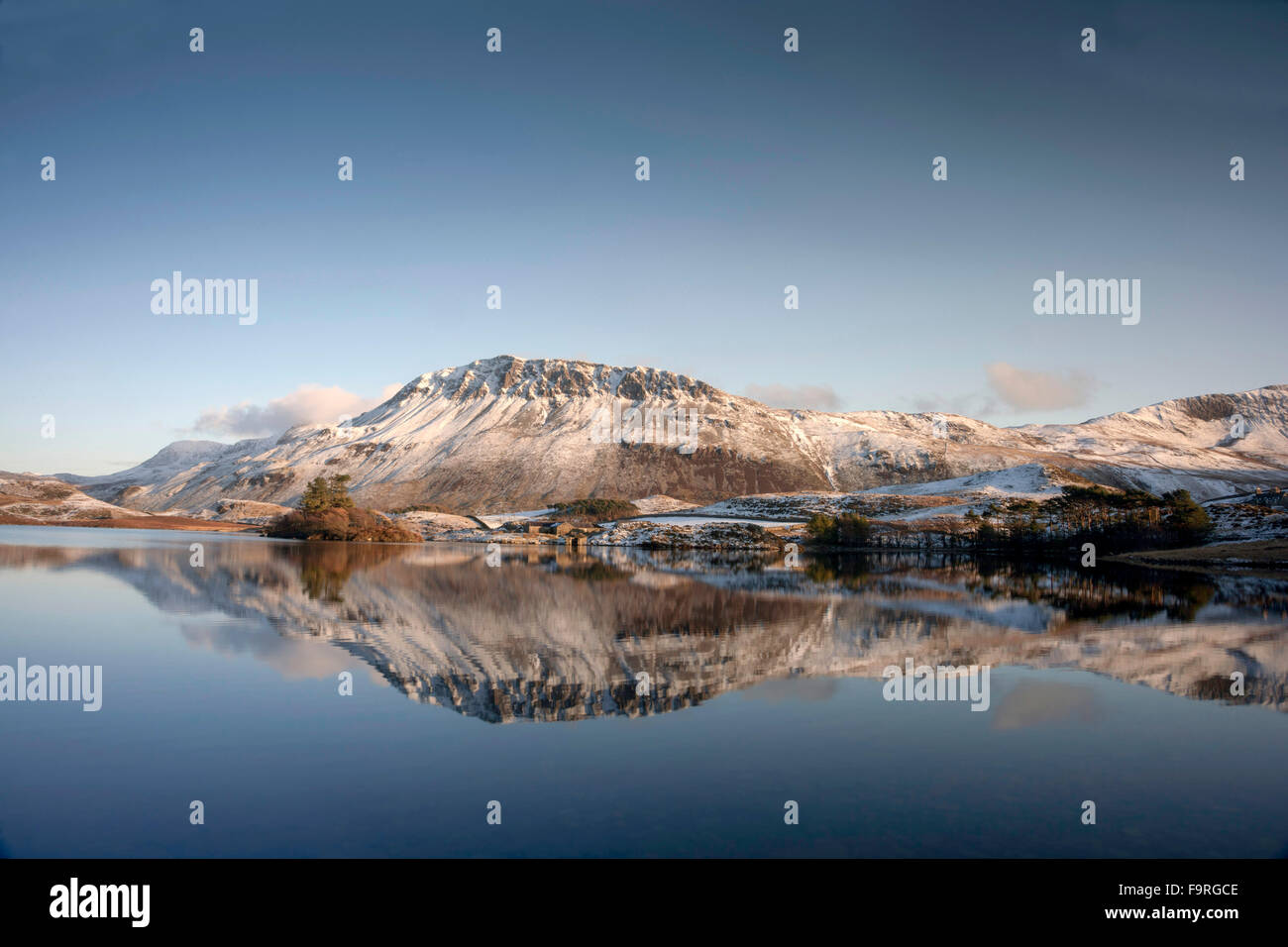 The winter snow covered slopes of the Cader Idris mountain range are reflected in the still water of Cregennen Lakes. Stock Photo