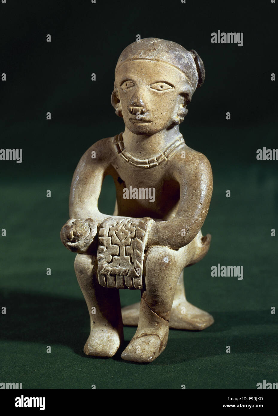 The Ancient Jama-Coaque Culture. Northern coast of Ecuador. 500 BC-500 AD. Ceramic figure made in mold. He holds in his hands a fabric. From Ecuadorina coast. Private collection. Stock Photo