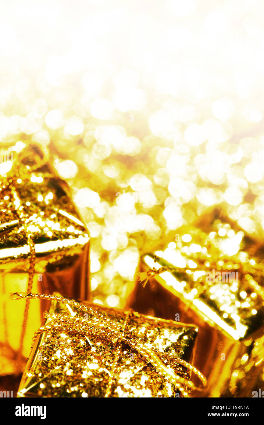 Decorative golden boxes with holiday gifts on shiny glitter background Stock Photo
