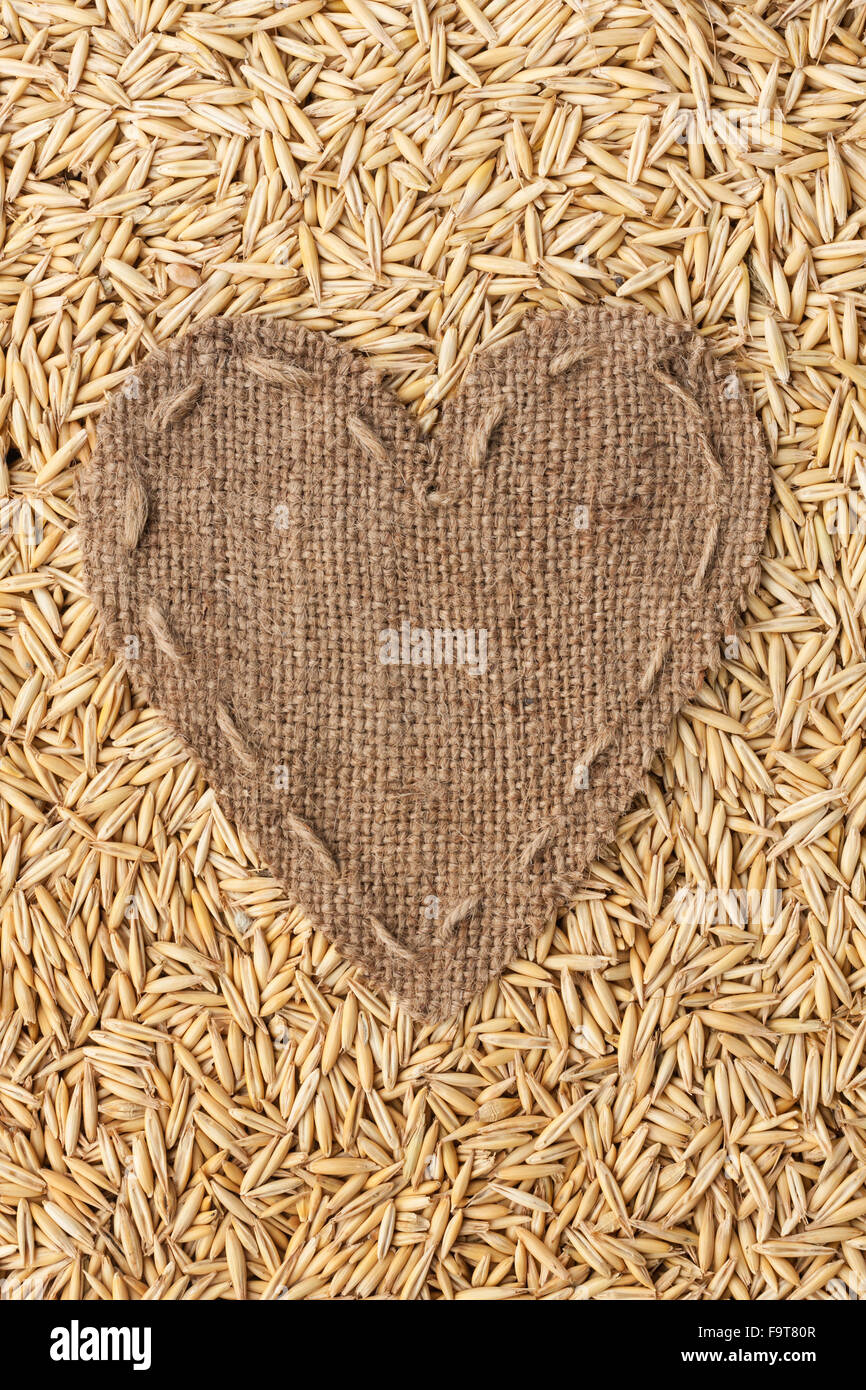 Frame in the shape of heart made of burlap with oats, with space for your text Stock Photo
