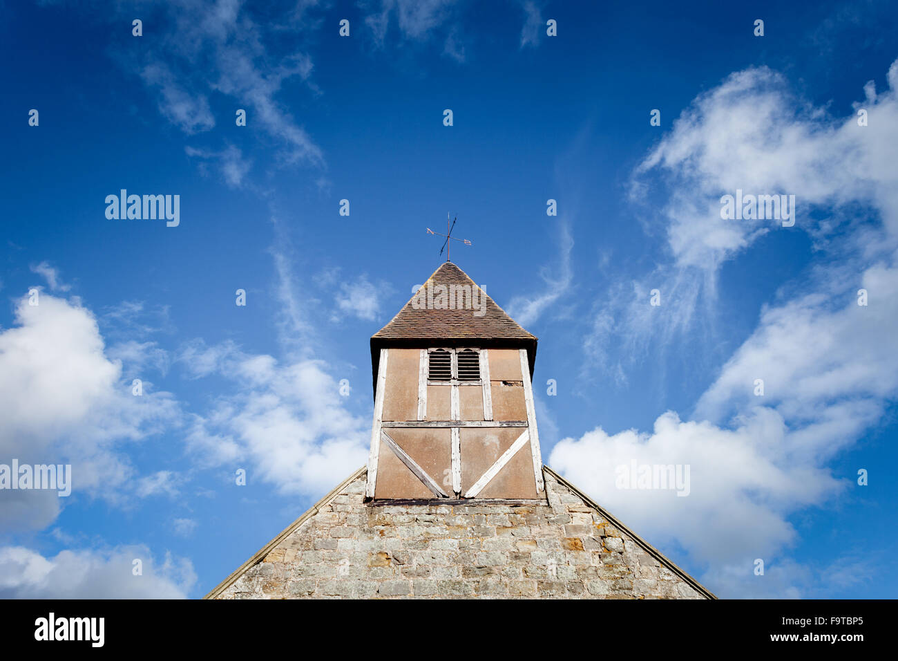 17th Century British Church Tower Bell on Cloudy Blue Sky Stock Photo