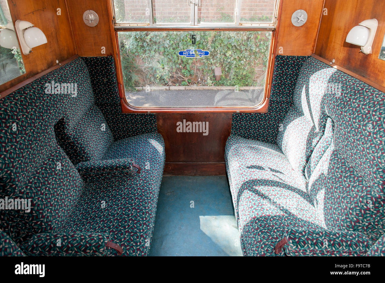 Inside a vintage British passenger train carriage with seating Stock Photo