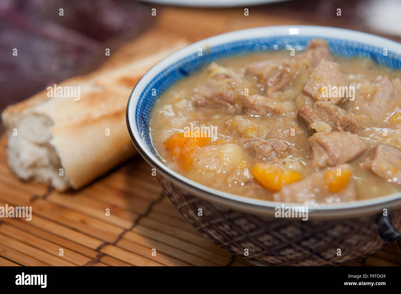 Close up of a bowl of lamb stew in bowl with bread stick Stock Photo