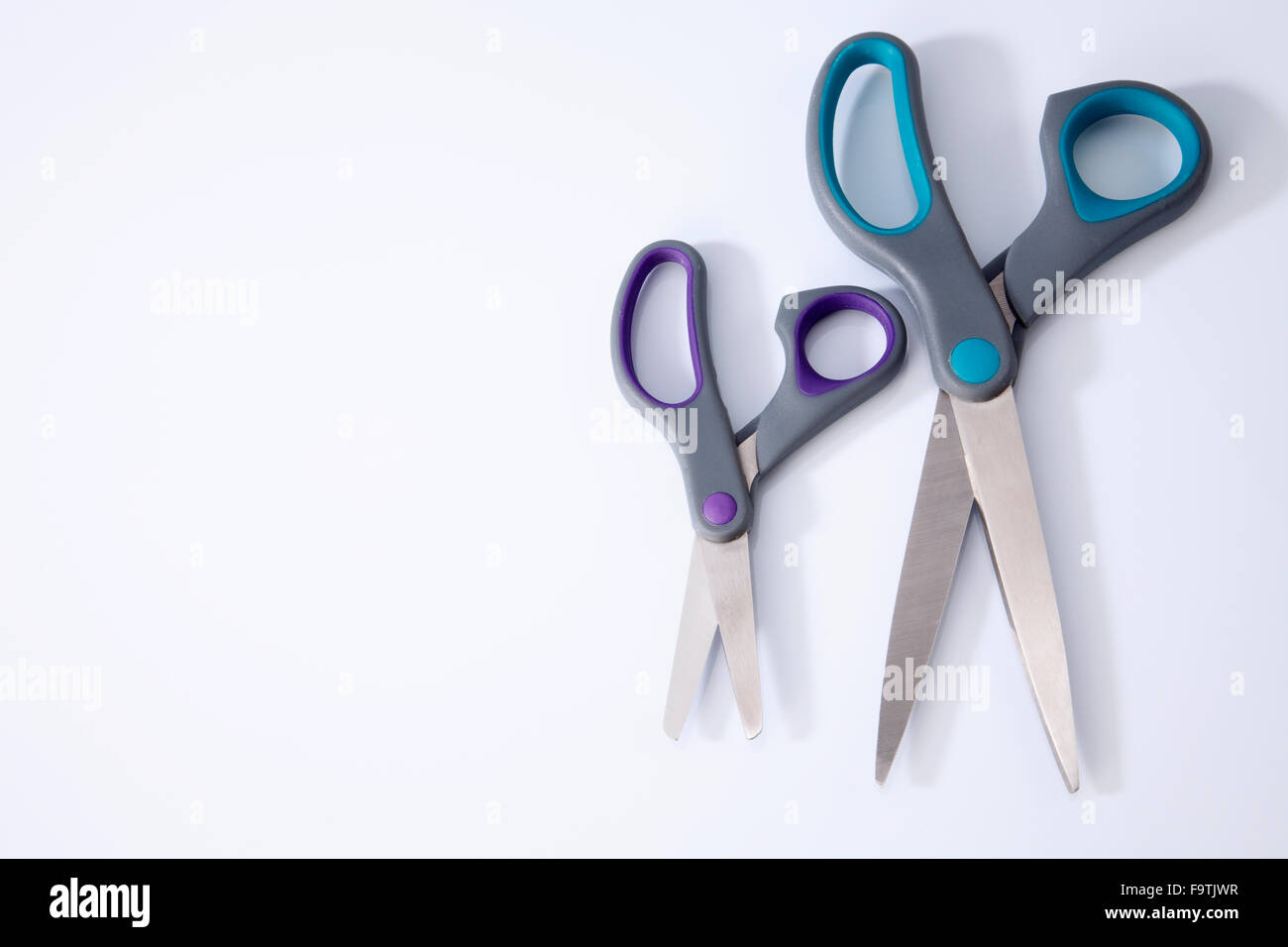 two pair of scissors which one big and small on the white background ...