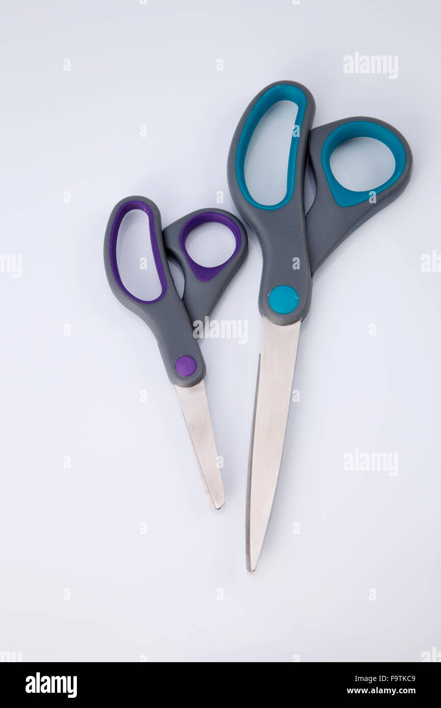 two pair of scissors which one big and small on the white background ...