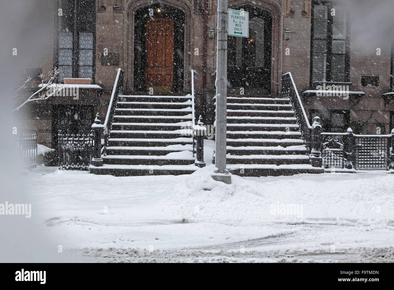 Snow covered Brooklyn brownstone townhouse stoops and sidewalk in winter Stock Photo