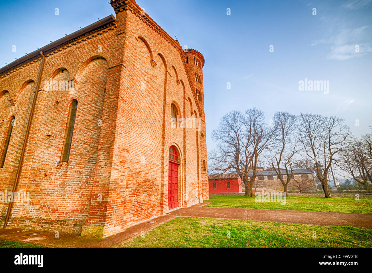 Ancient brick walls of an old Catholic church with one of the oldest  belltowers in Italy Stock Photo