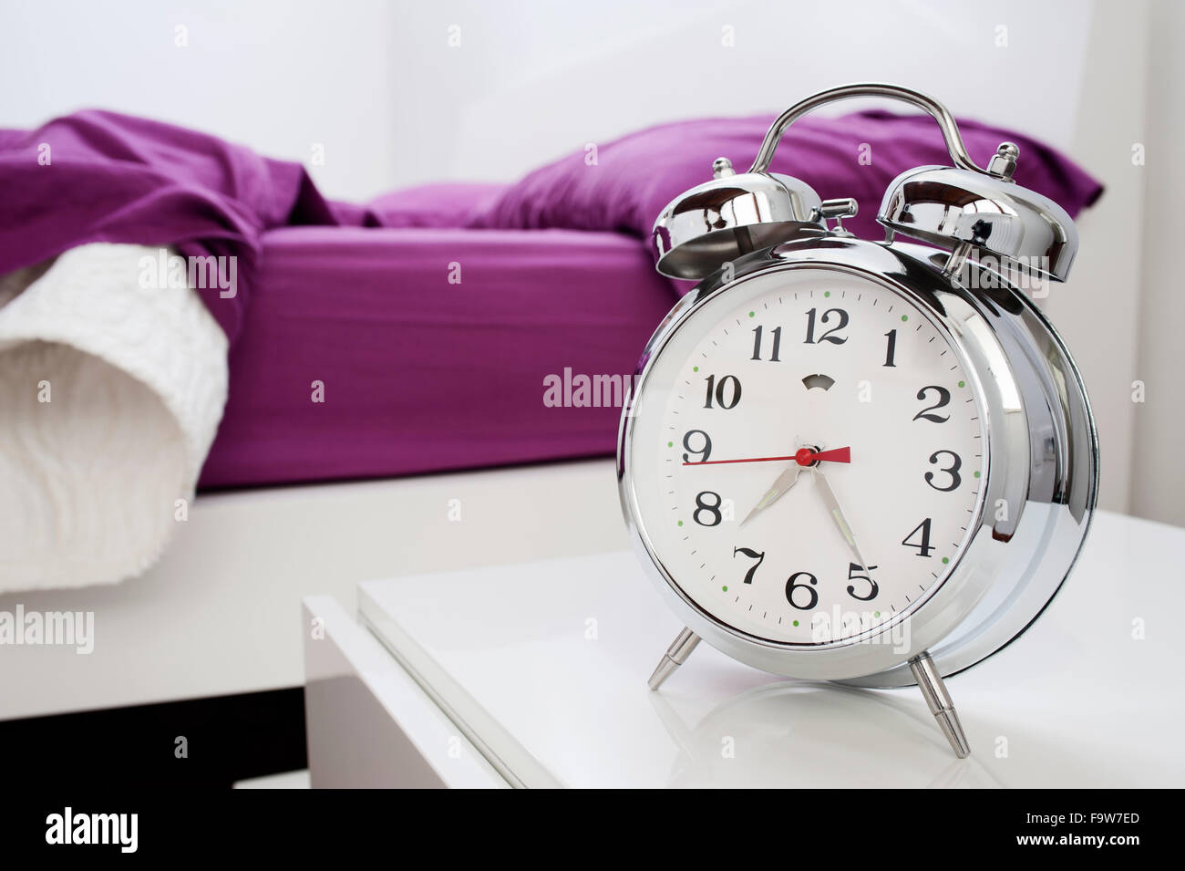 classical alarm clock on bedside table Stock Photo Alamy