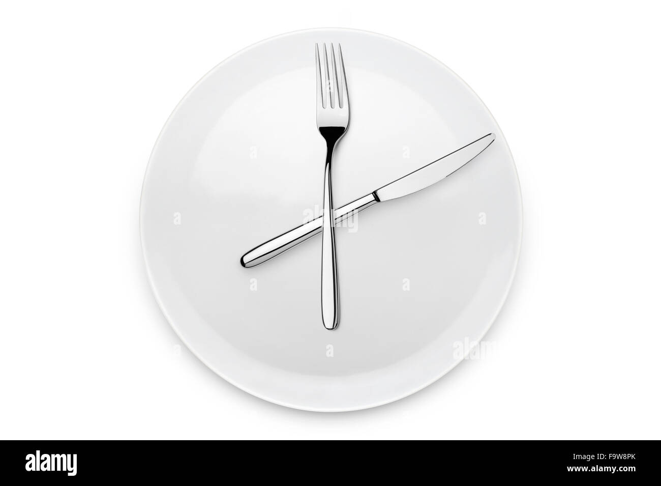 plate with fork and knife at twelve o'clock position, on white background Stock Photo