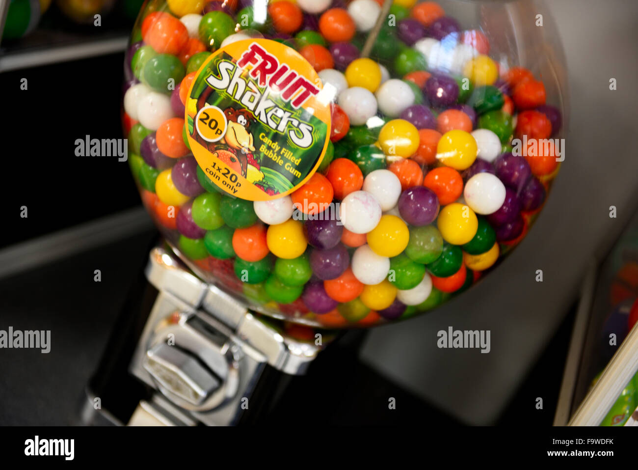 Colourful round sweets (candy filled bubble gum) in coin operated candy dispensing machine in shopping centre Stock Photo