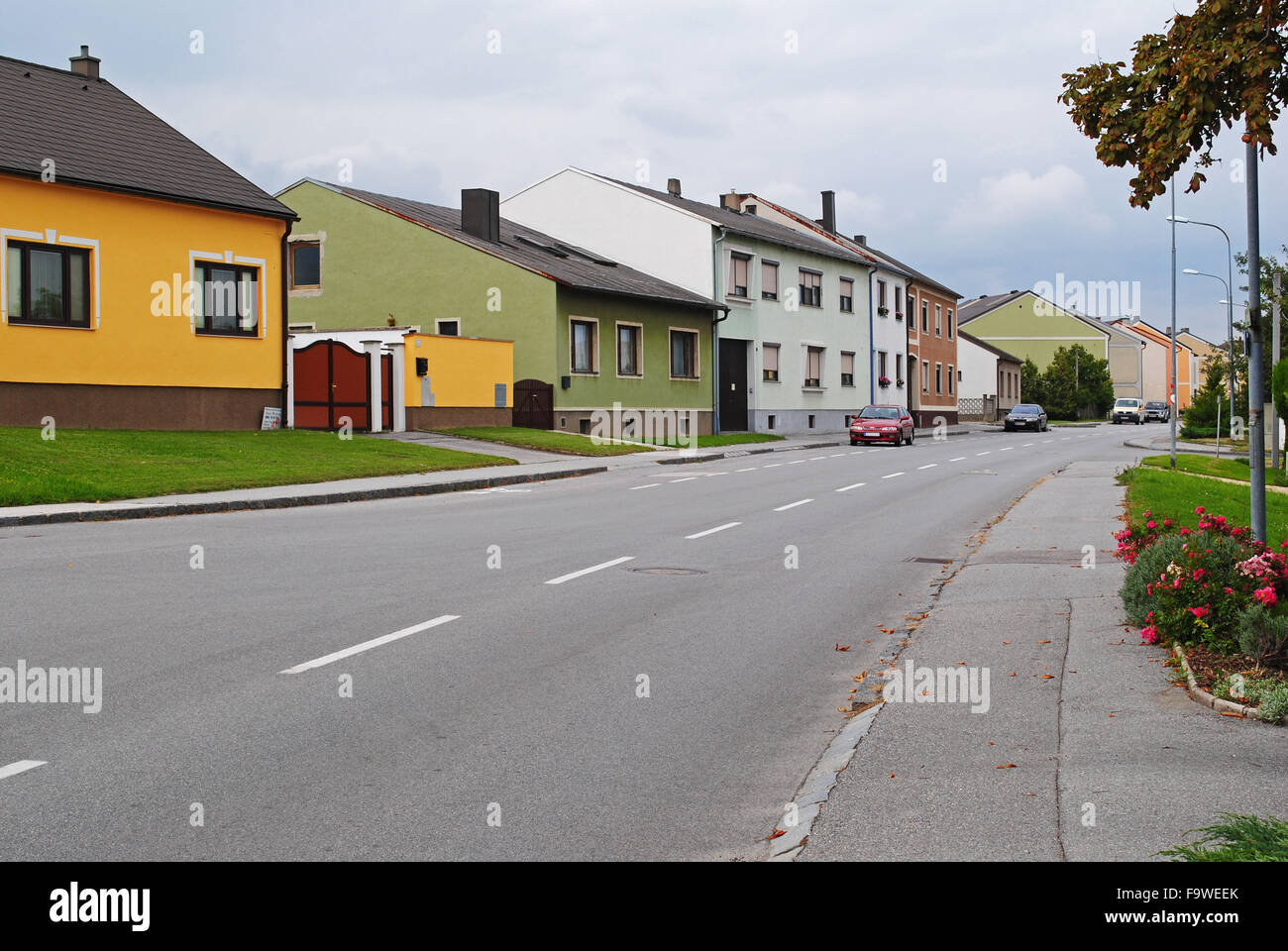 Austrian street scene with a wide road and modern, colourful houses in a small village. Stock Photo