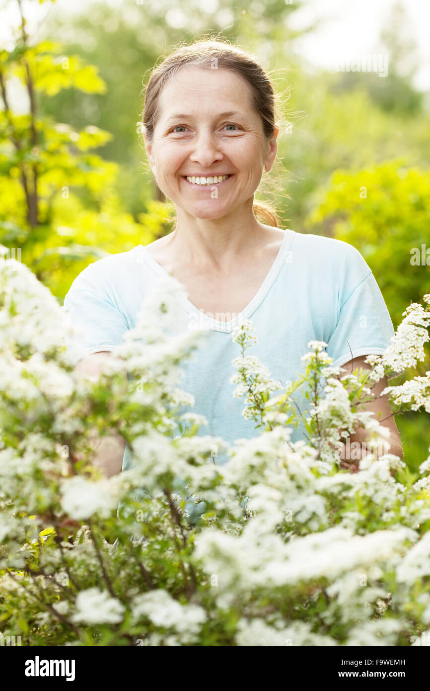 Happy mature woman with flowers at garden Stock Photo - Alamy