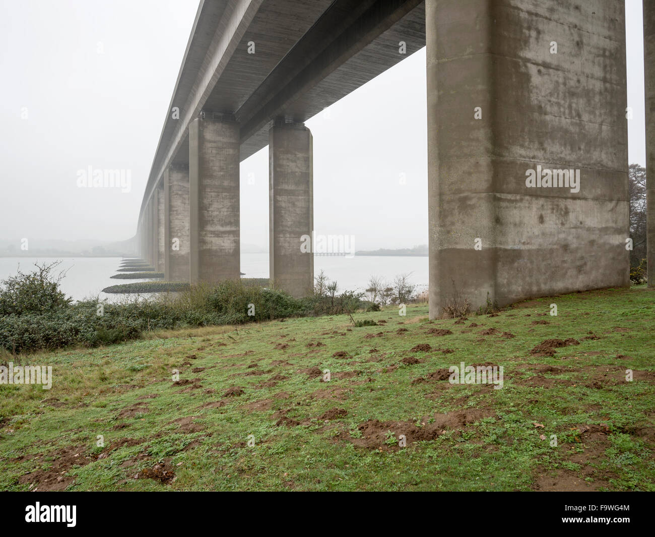 Imposing bridge spanning a calm misty waterway Stock Photo - Alamy