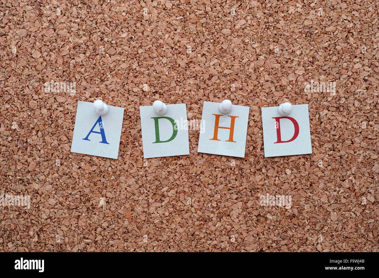 ADHD letters pinned to a cork notice board. ADHD is Attention deficit