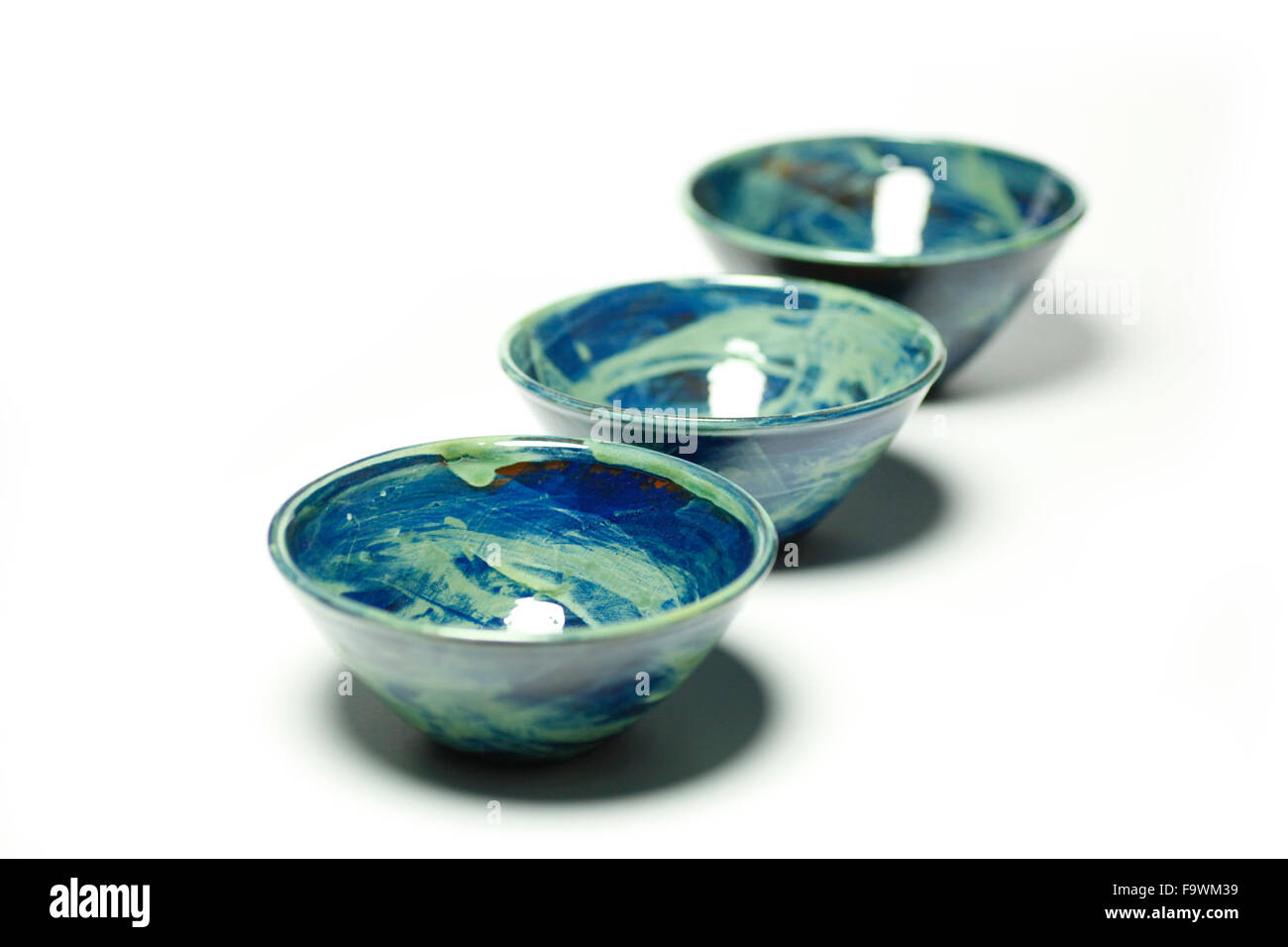 Blue ceramic bowls made by Sally Bettridge isolated on a white studio background. Stock Photo