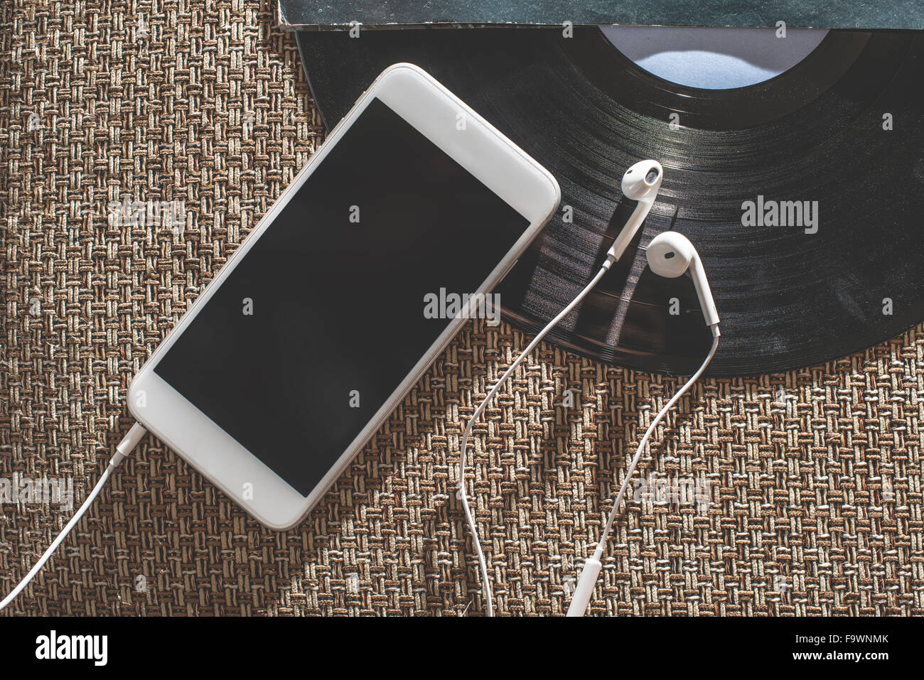 Smartphone, earphones and a record Stock Photo Alamy