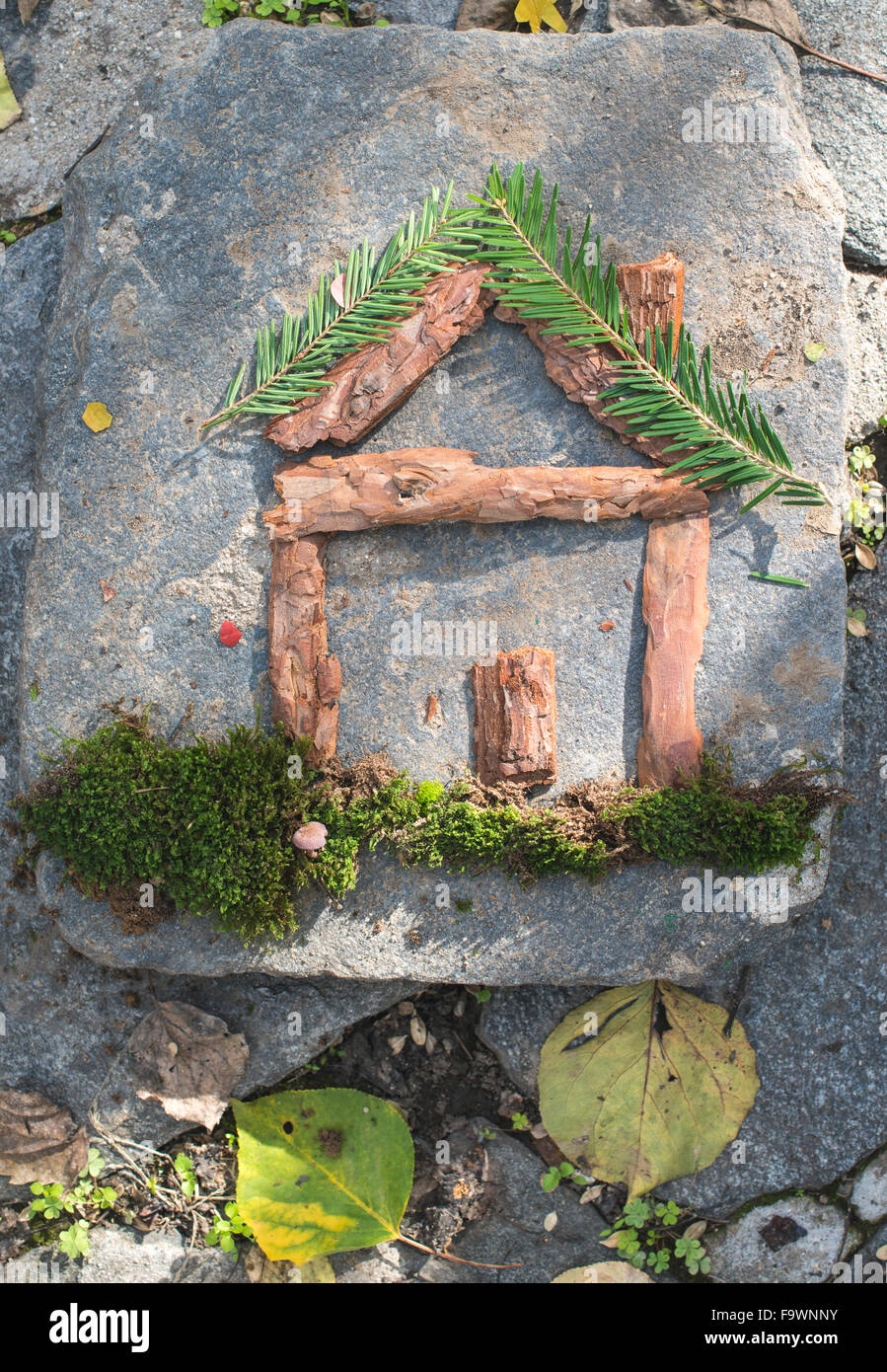 Pieces of fir branch, lichen and bark building shape of a house Stock Photo