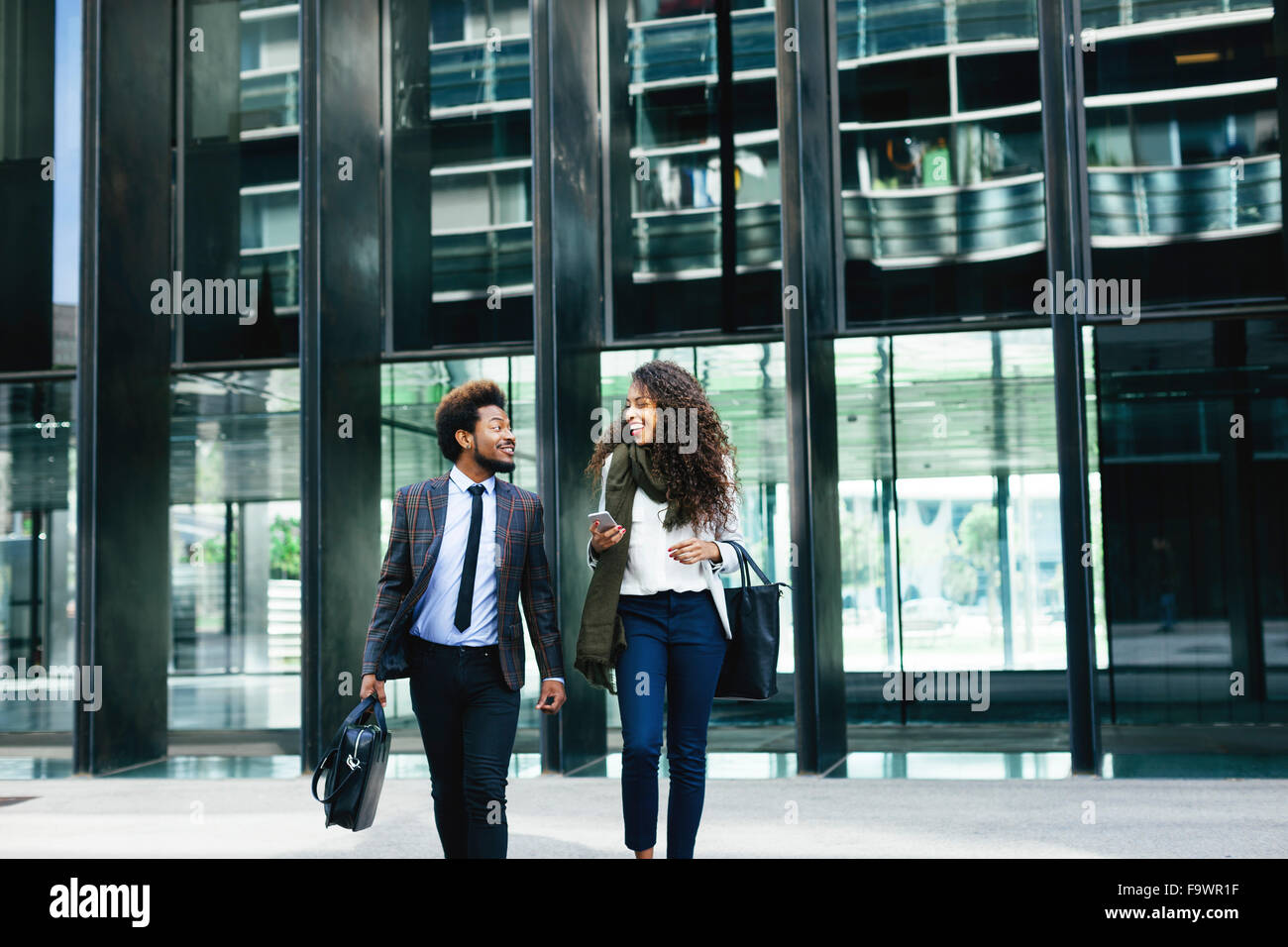 Two young business people walking outdoors Stock Photo - Alamy