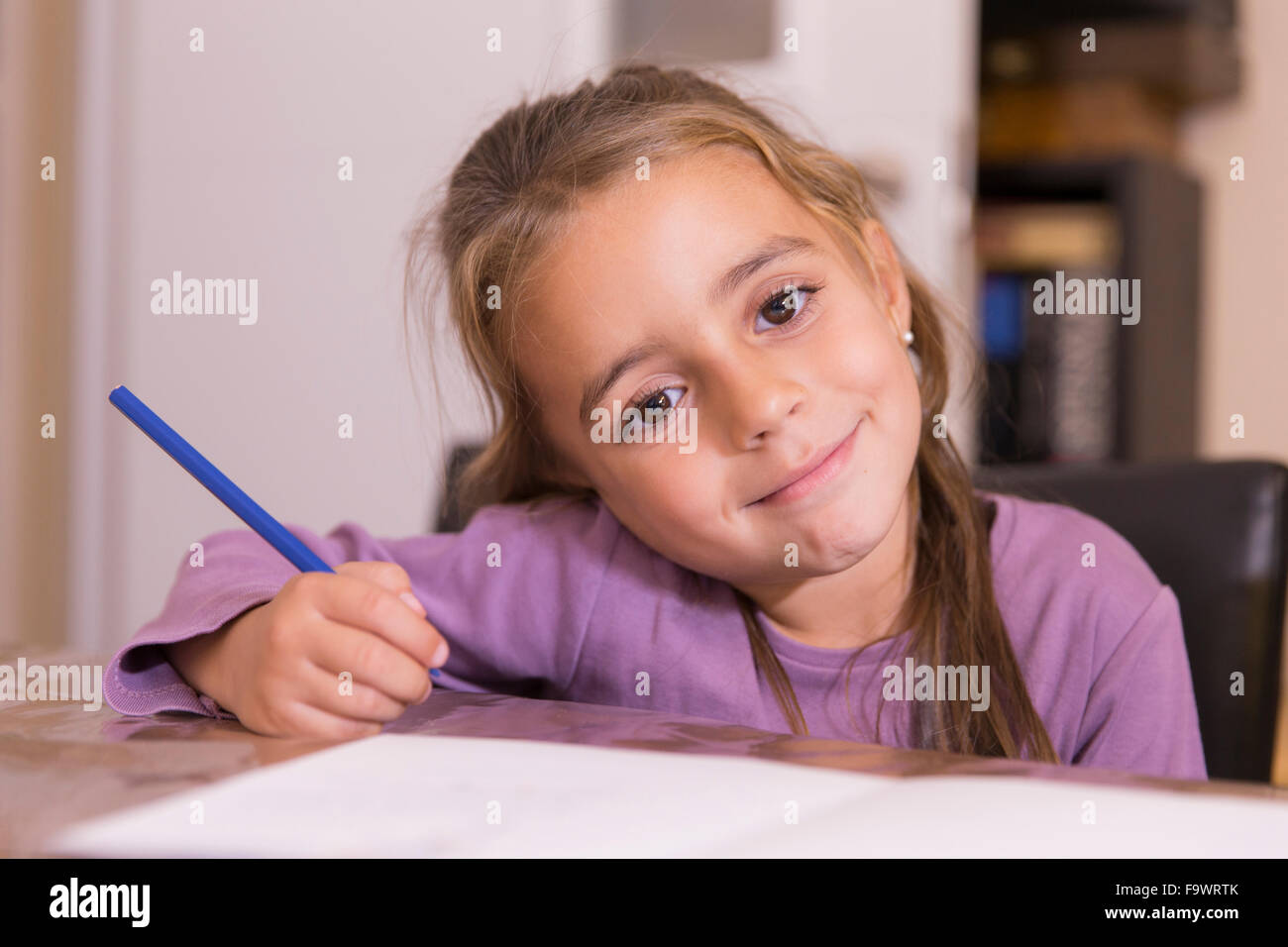 Portrait of smiling little girl with blue pencil Stock Photo - Alamy