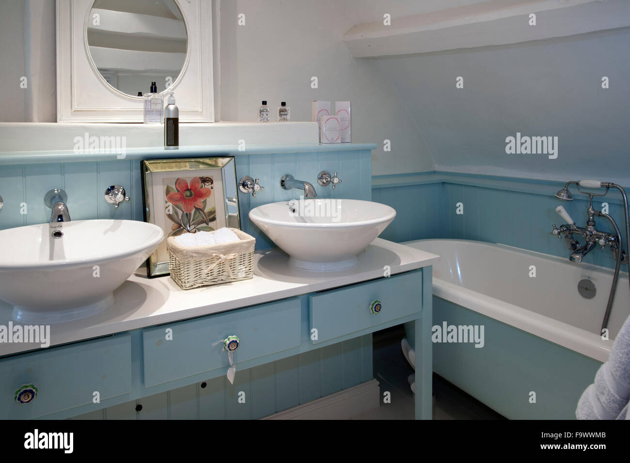 Blue painted bathroom with his and hers wash basins. Stock Photo