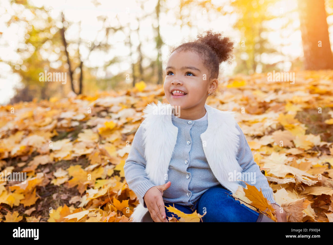 Little girl playing in autumn park Stock Photo - Alamy