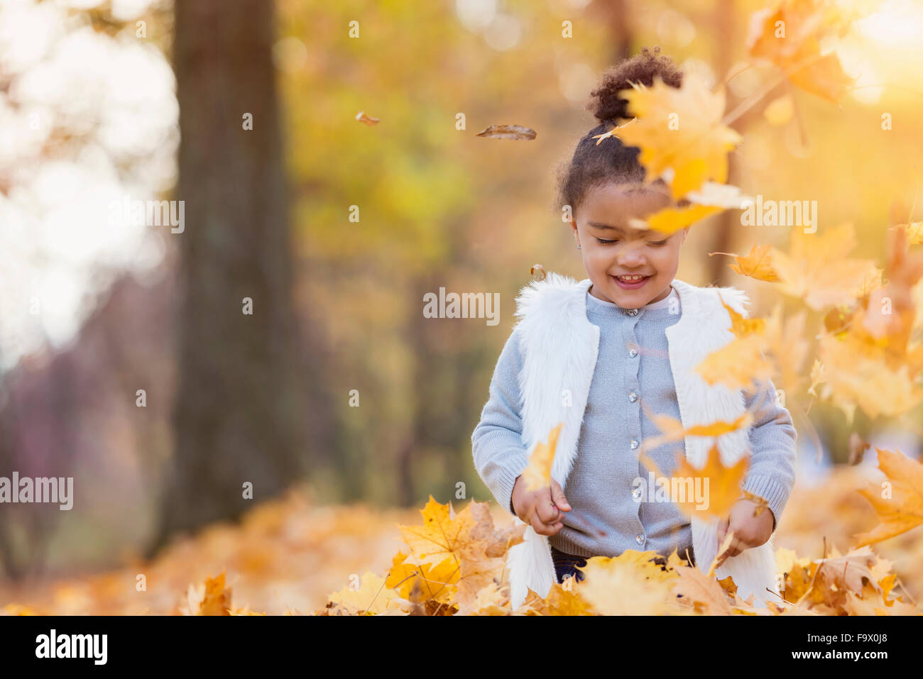 Little girl playing in autumn park Stock Photo - Alamy